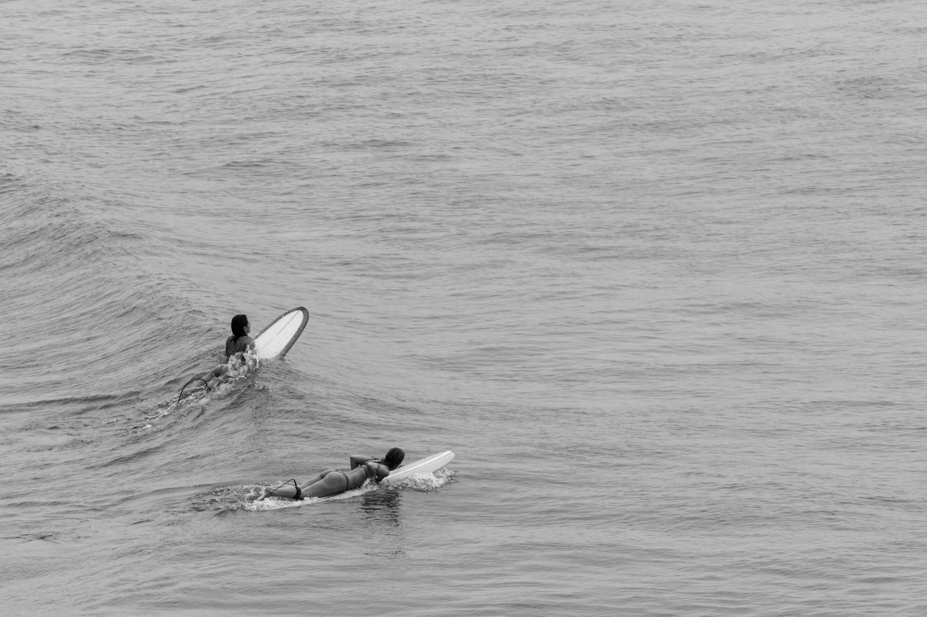 women on surfboards in black and white